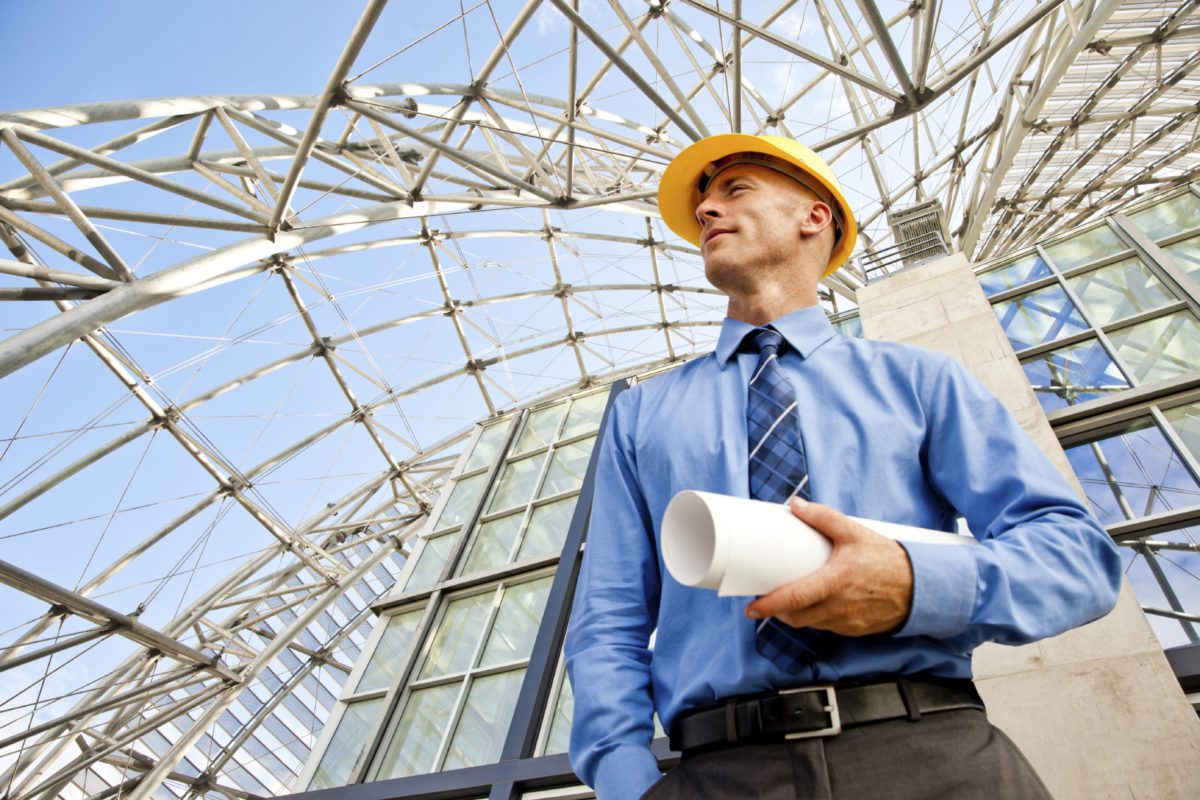man with a hard hat holds plans