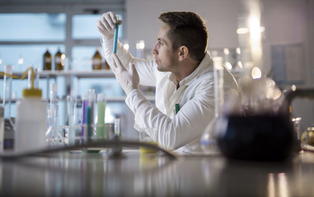 Male chemist examining chemical substances in a laboratory.