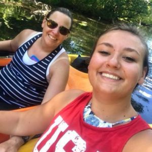 mother/daughter graduates smiling, sitting in a kayak