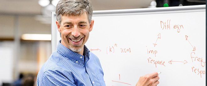 Professor Barry Vanveen teaches in front of a white board