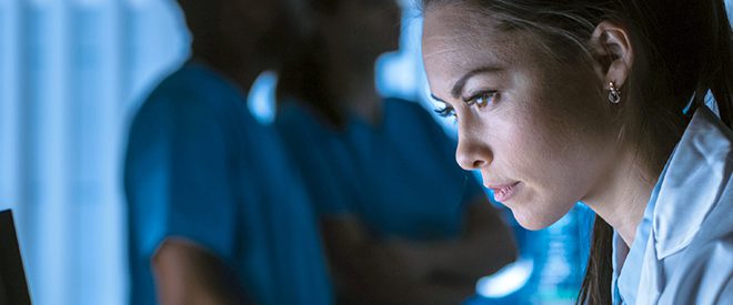 A medical professional looks at a computer screen.