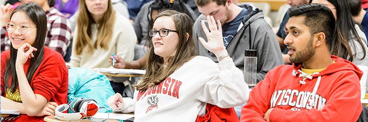 A UW–Madison student raises her hand in class.
