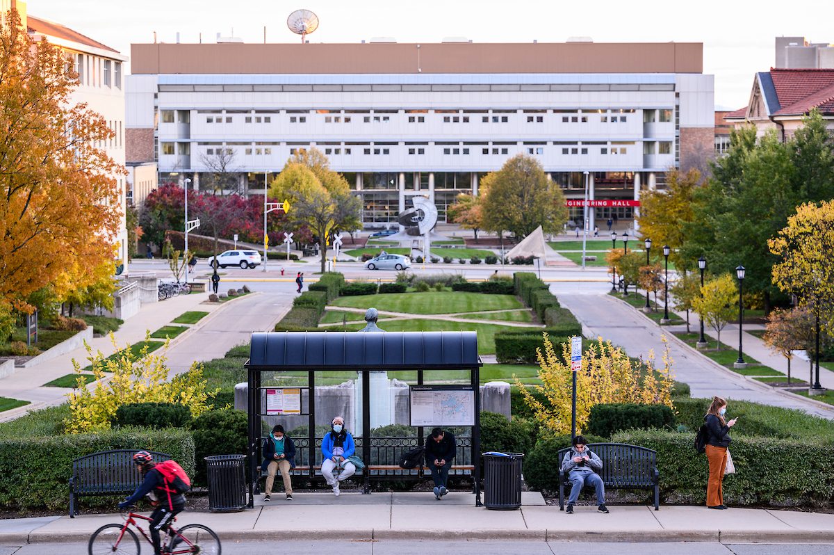 UW–Madison Engineering Hall in the backdrop of a busy campus scene in autumn.