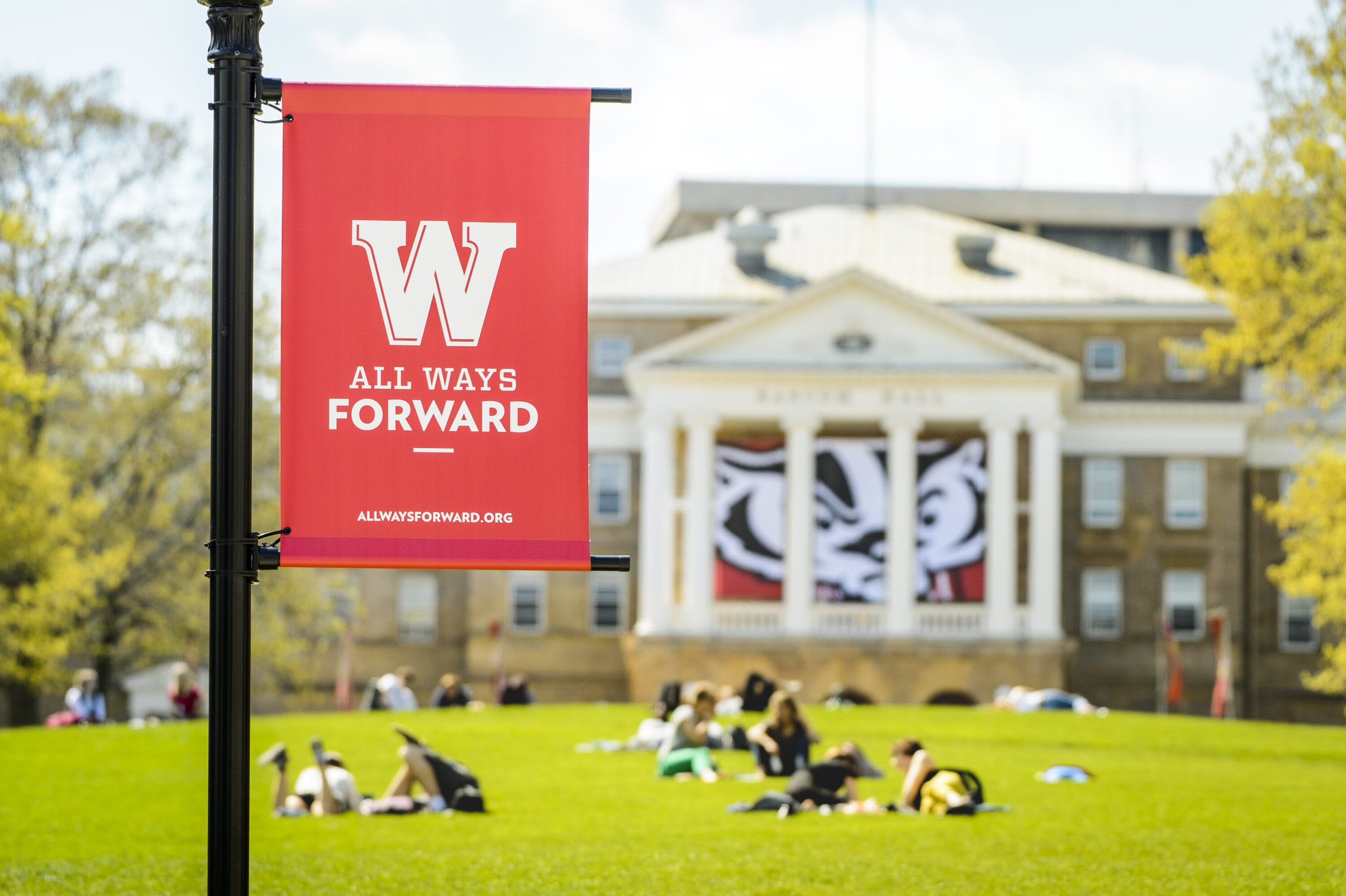 A "All ways forward" flag raised before Bascom Hall.