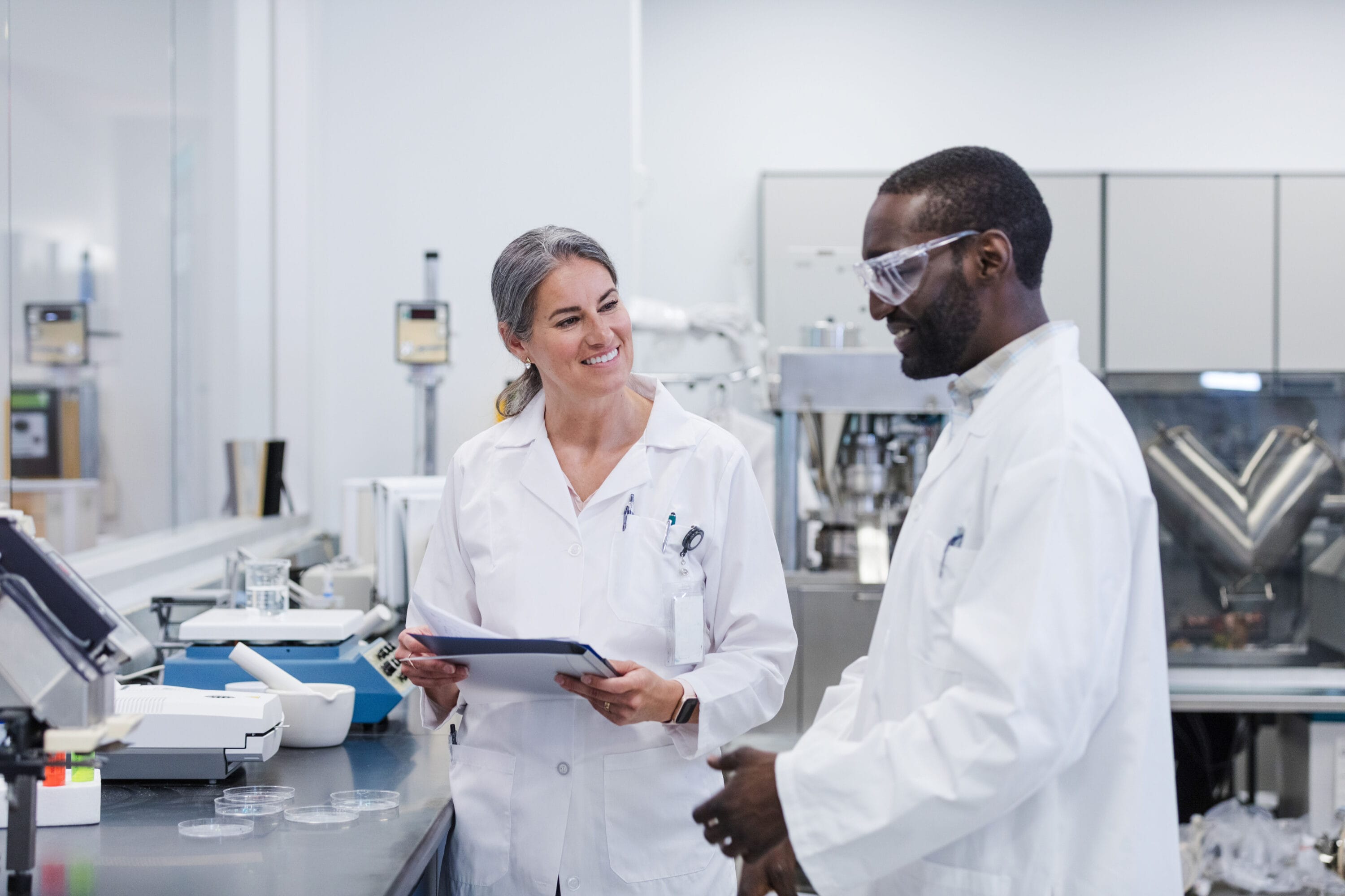Two scientists in lab coats working in a lab.