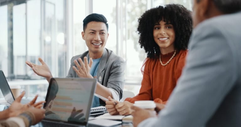A group of young professionals speaking amongst each other in a meeting.
