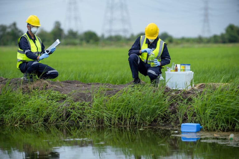 Two field workers testing water.