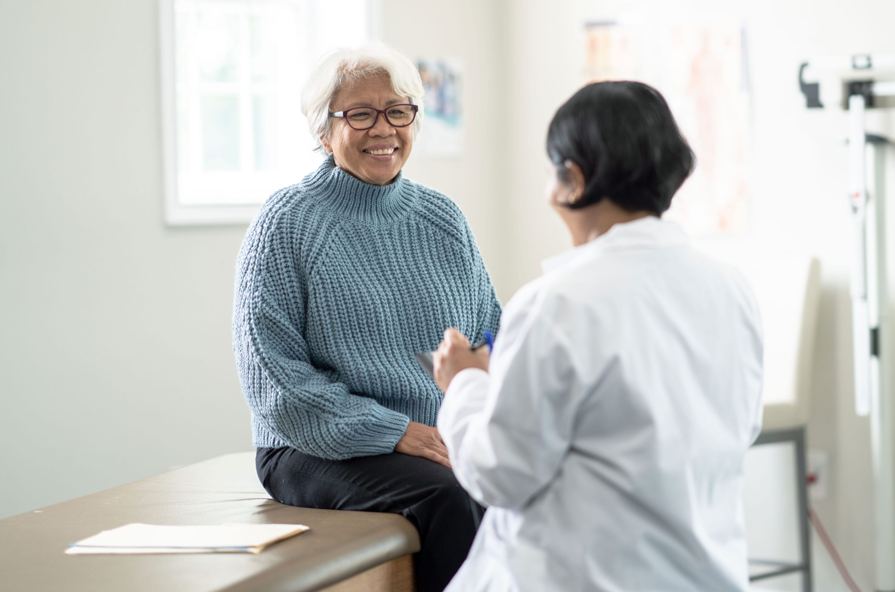 A patient and a doctor are having a conversation in a hospital room.
