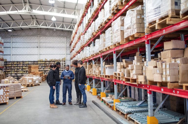 Three manufacturing workers in a warehouse.
