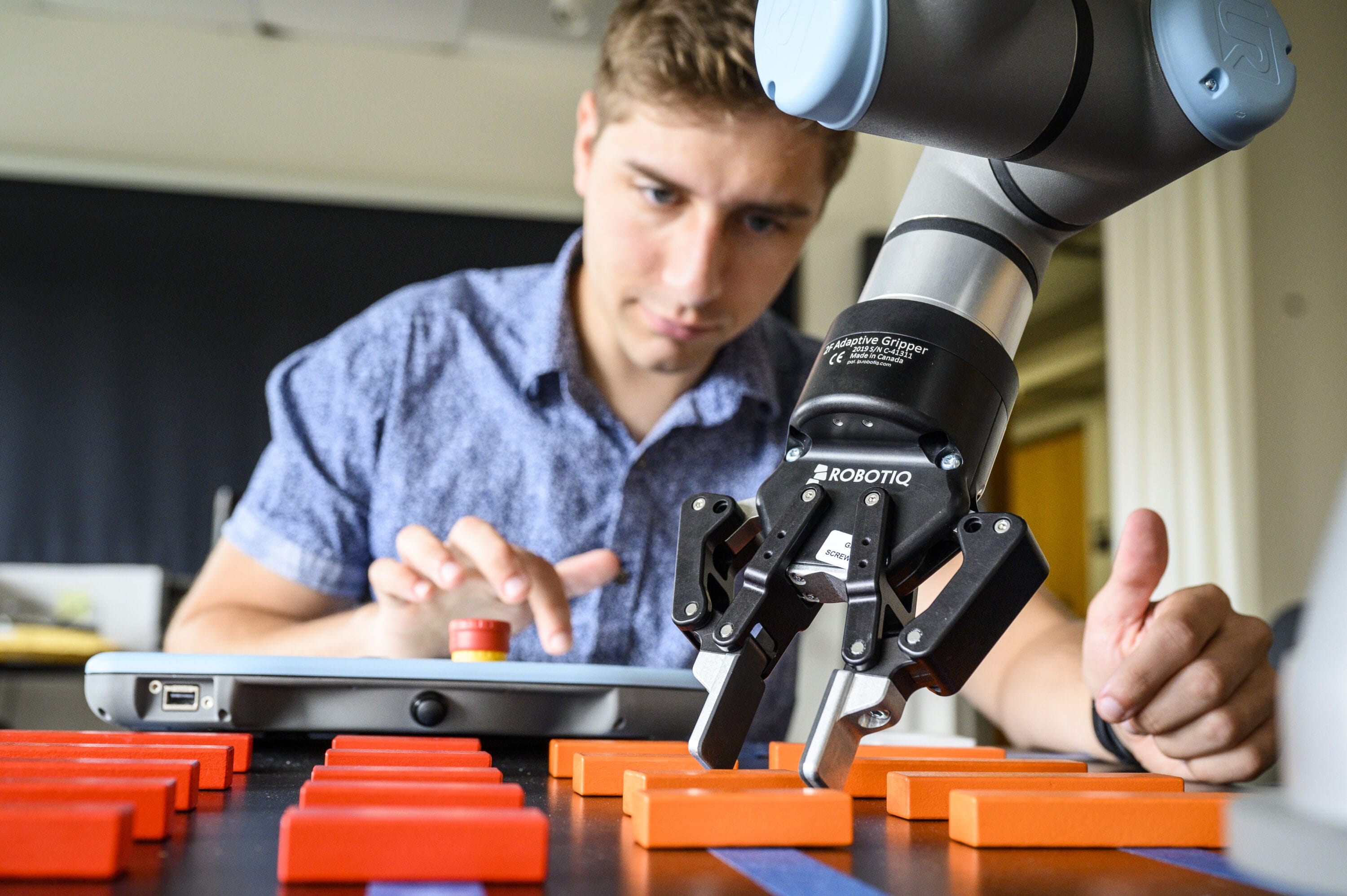 An engineering student working with a piece of machinery equipment in a lab.