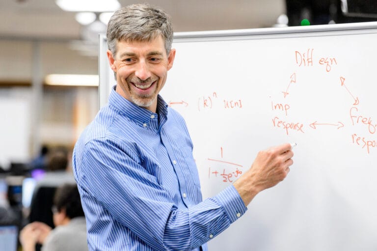 Professor Barry VanVeen writing on a whiteboard.