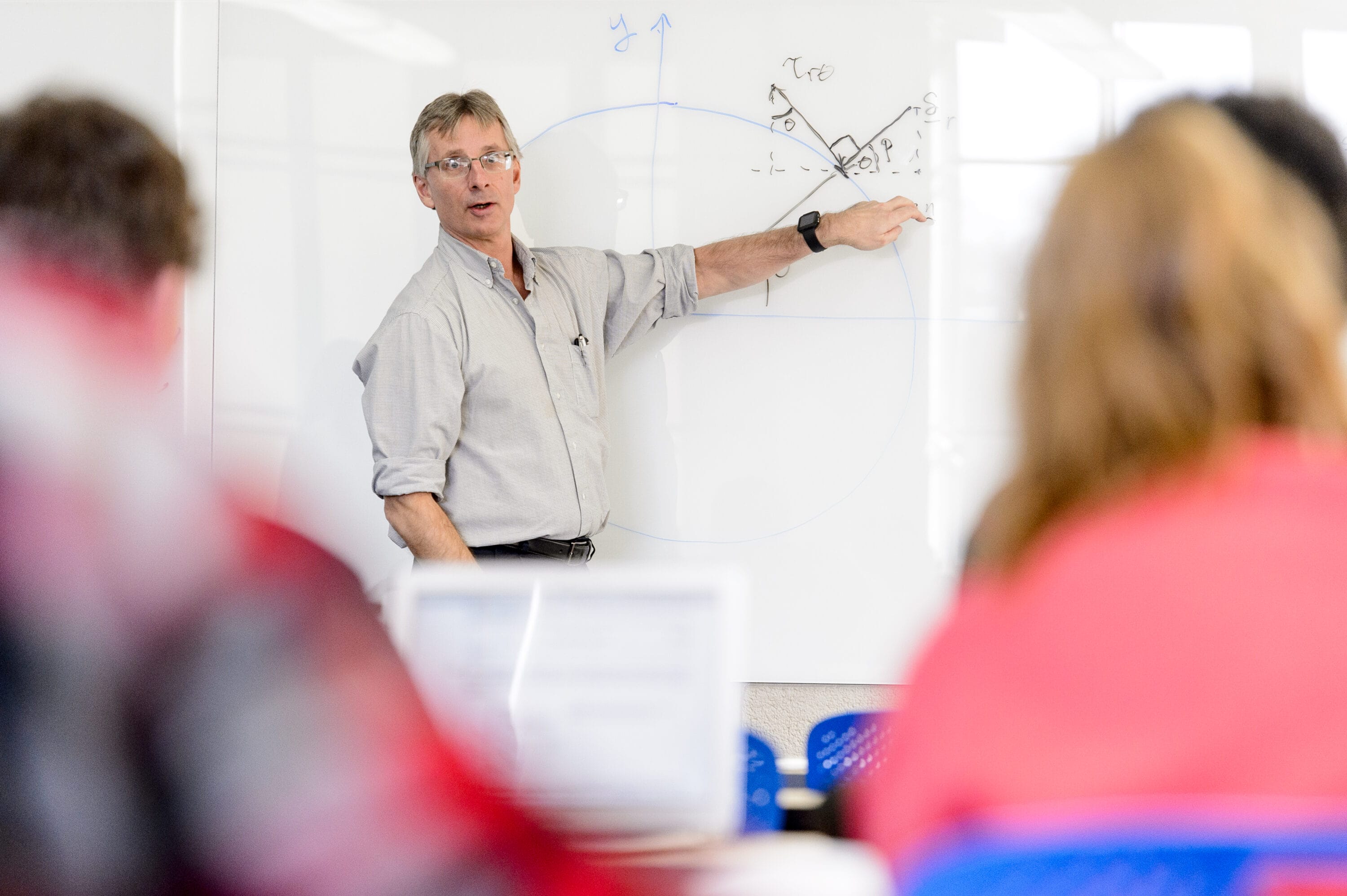 A professor writing equations on the board.