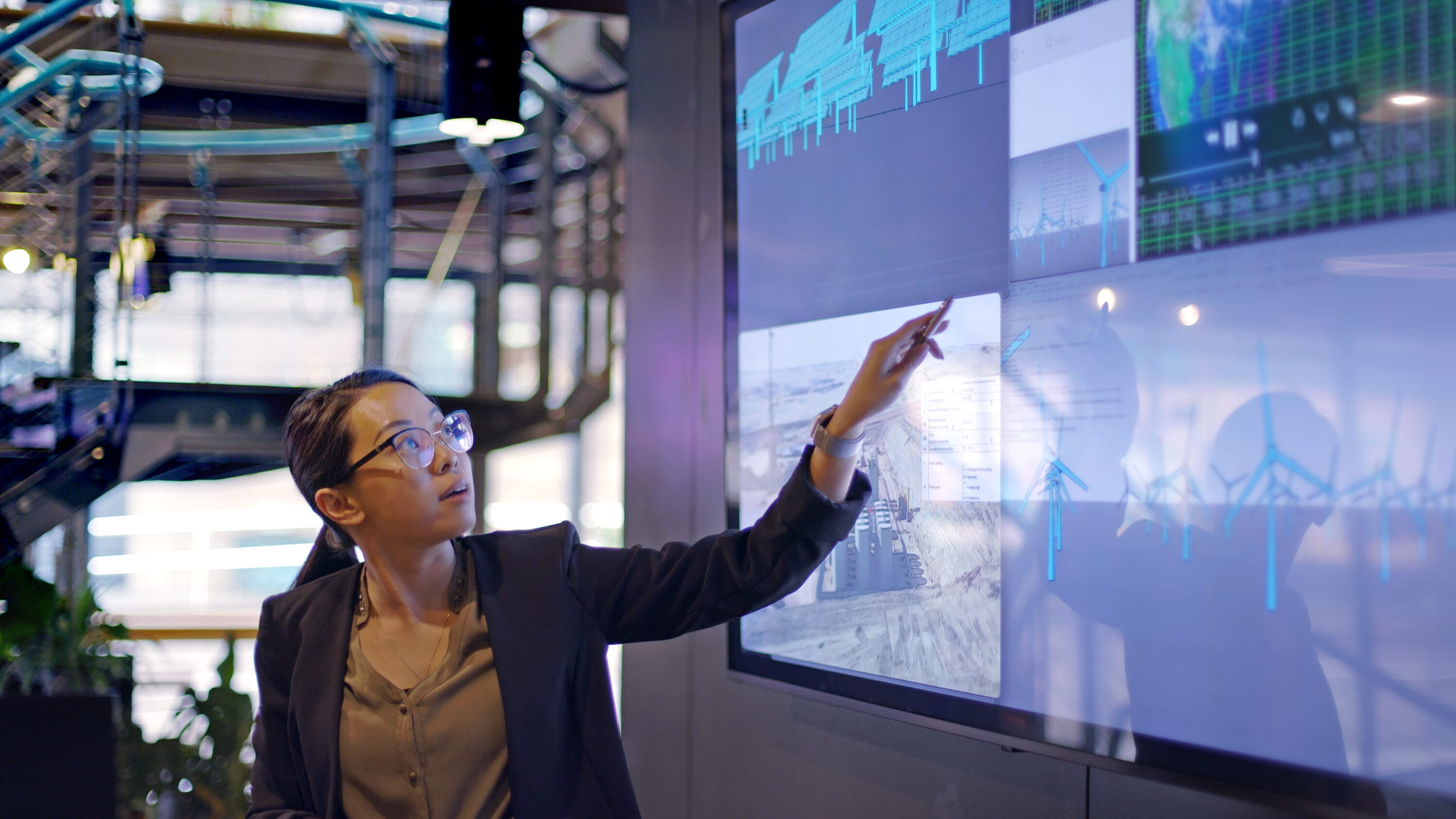 A woman reviewing data visualizations on a board.