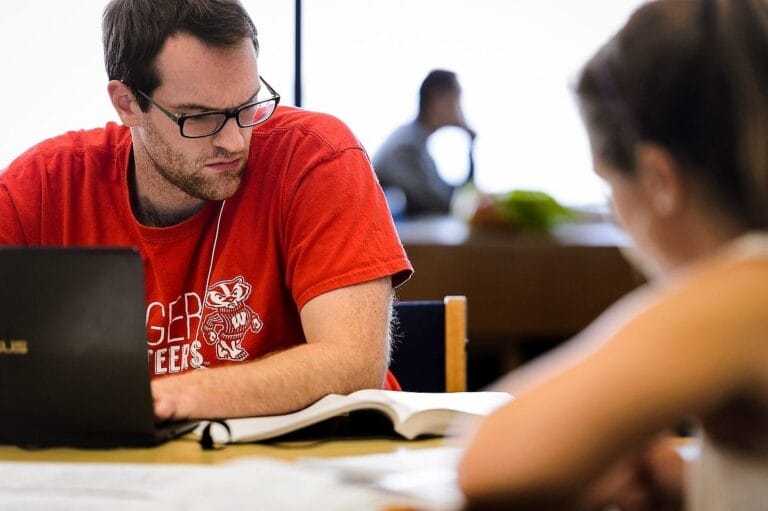 A UW-Madison student studying at the library.