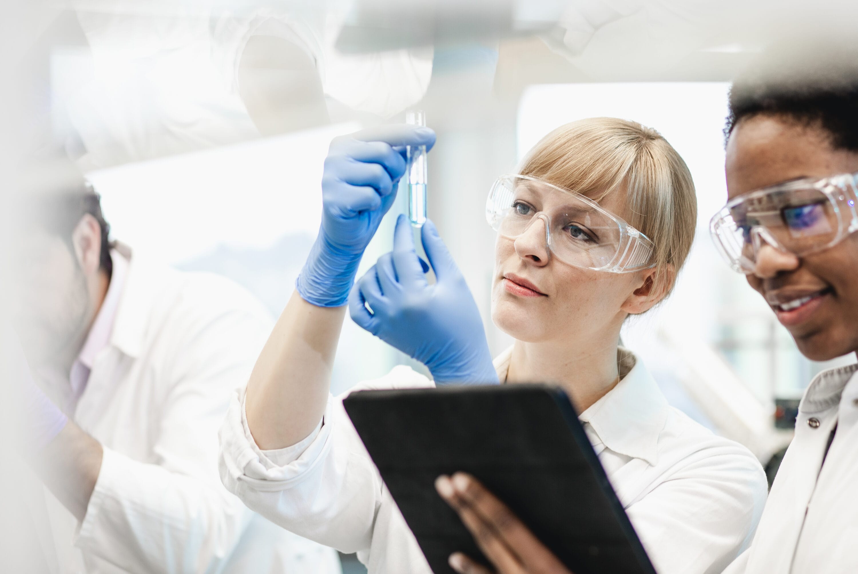 Two scientists wearing lab coats reviewing drug notes.