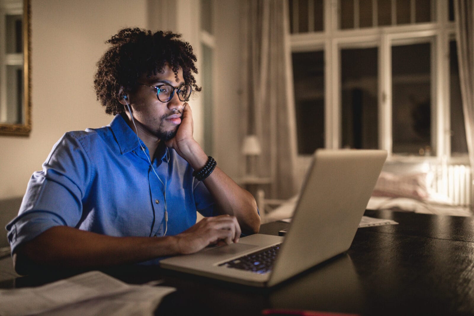 A man in his living room working on his laptop.