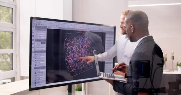 Two men reviewing data on a montior.