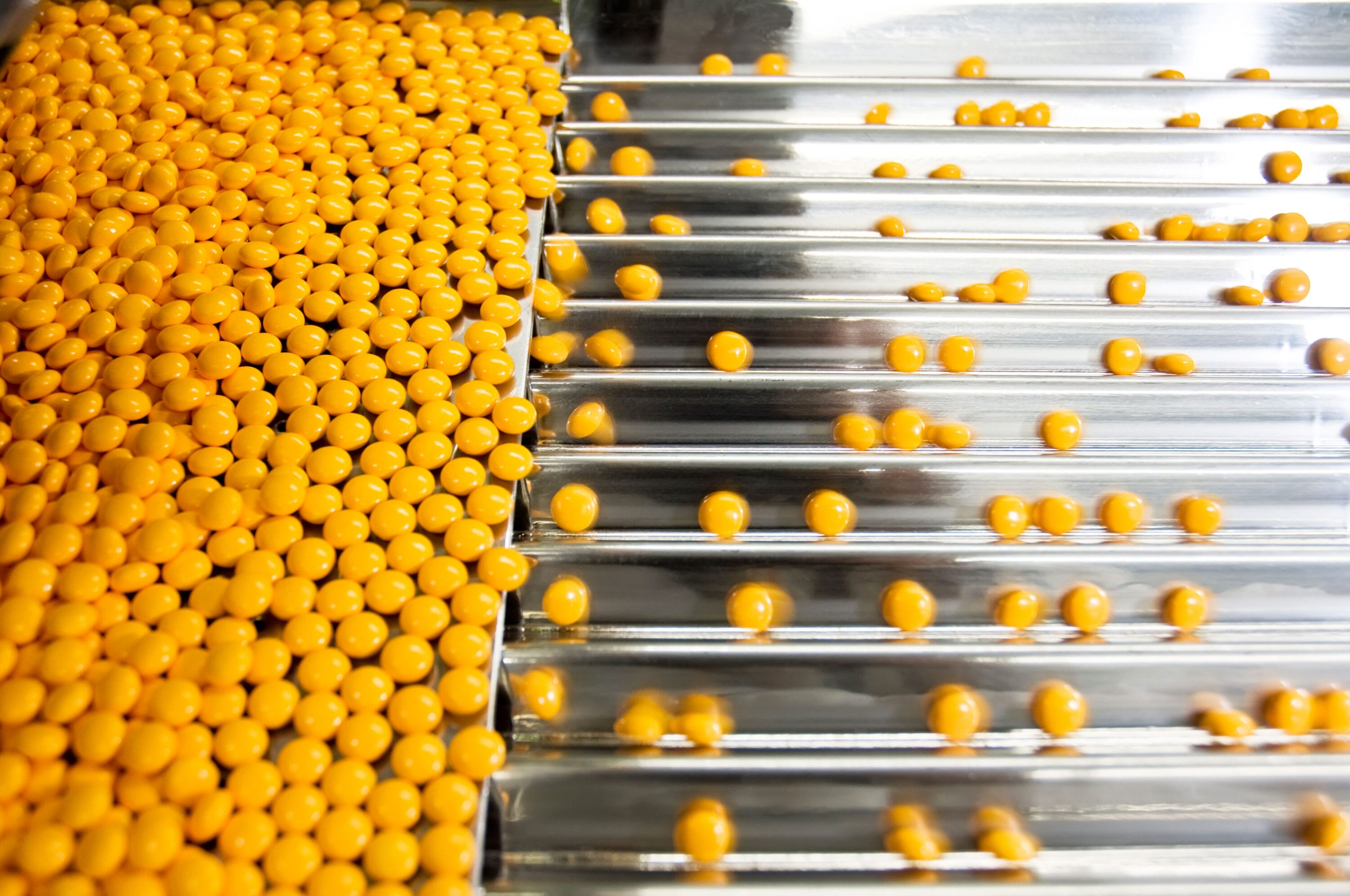 Lab pill mills sorting through circular yellow pills.