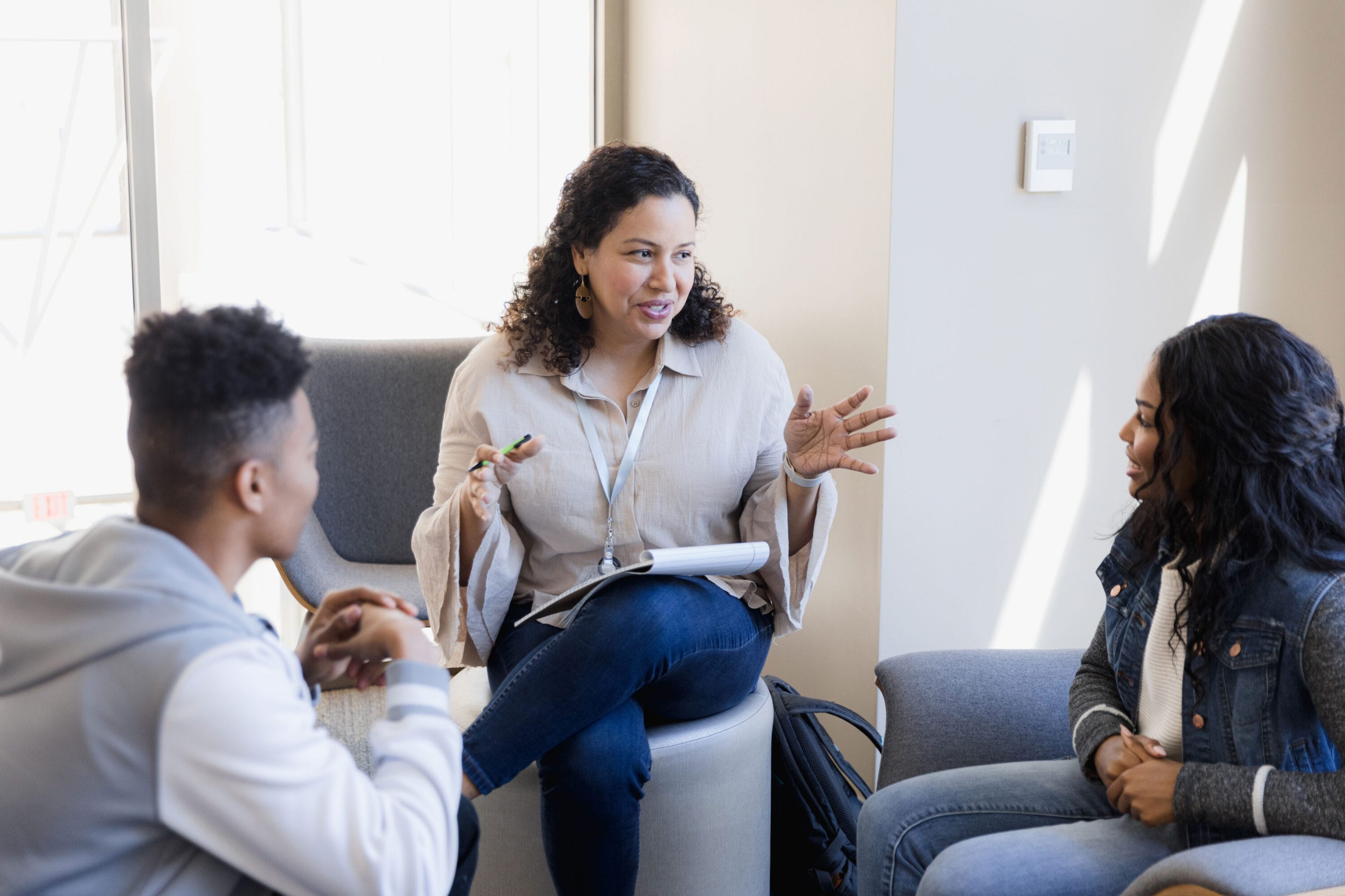 A therapist holding a session with two teenagers.