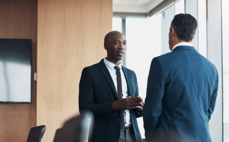 Two men in business suits having a conversation.