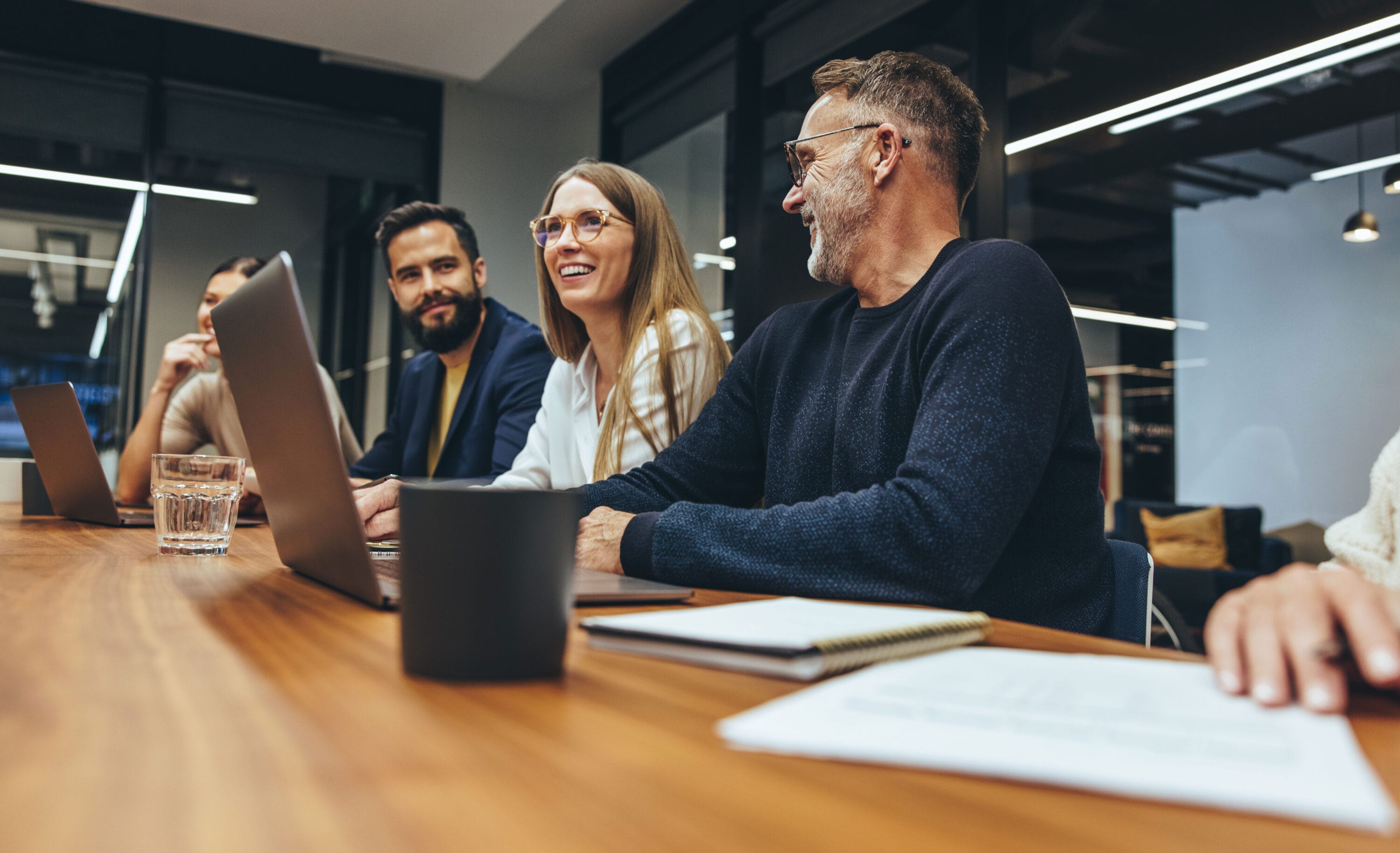 A group of people sitting at a conference table discussing.