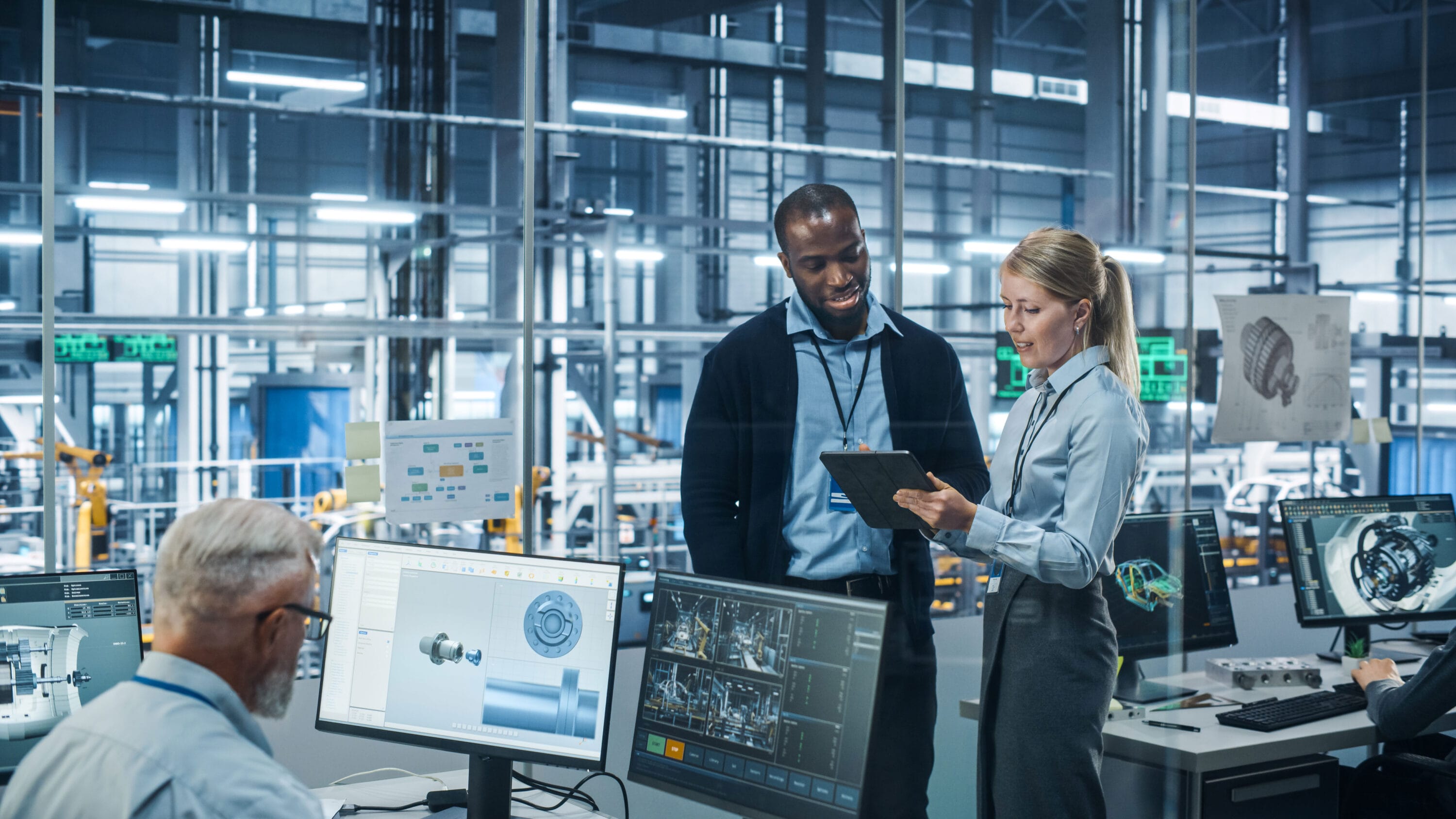 Three engineers reviewing schematics in an engine room.