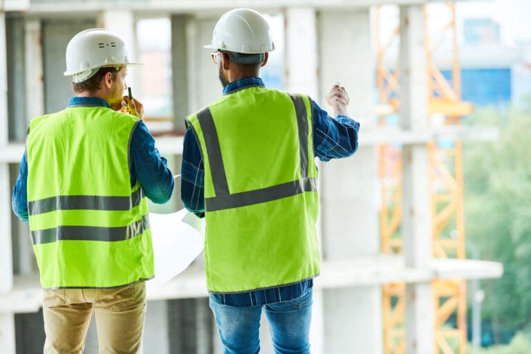 Two construction workers reviewing schematics.