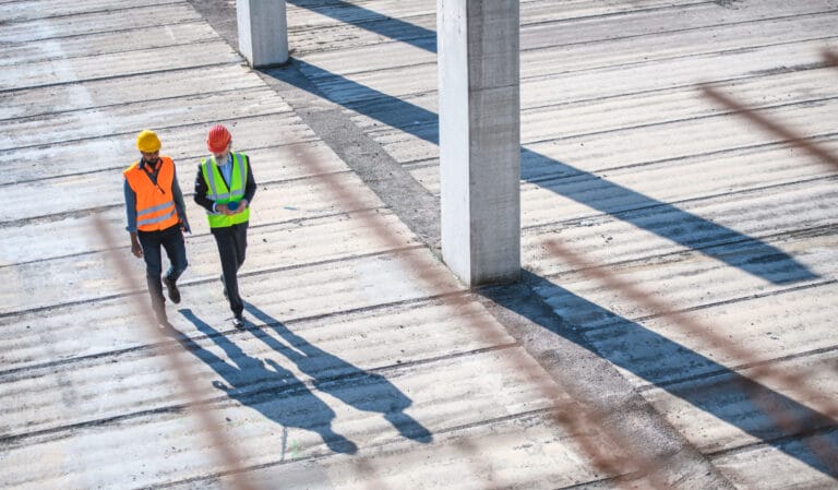 An aerial view of two men walking on a wooden boardwalk.