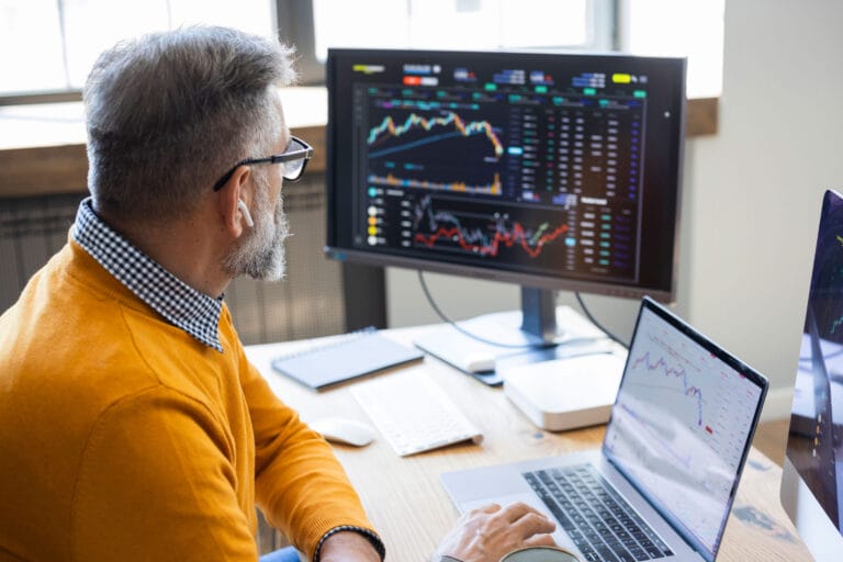 A man sitting at his desk reviewing data on his computer.