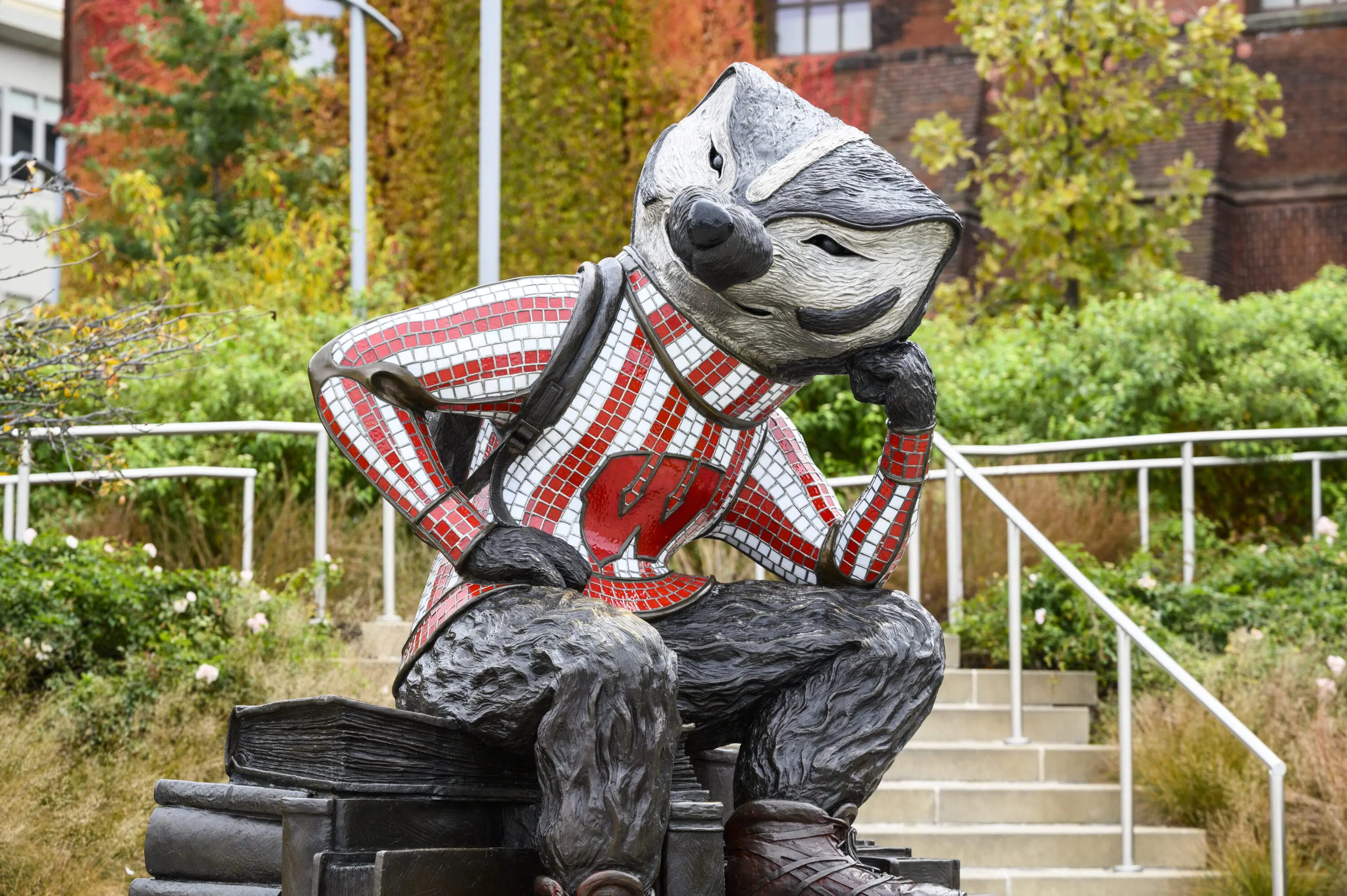 Statue of Bucky Badger posing with his elbow resting on his knee.