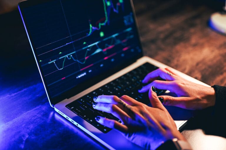 A pair of hands typing on a laptop